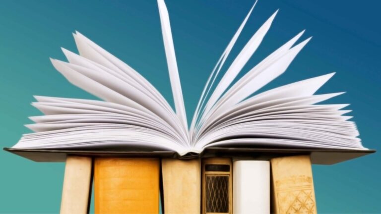 Open book with pages fanned out atop a stack of closed books