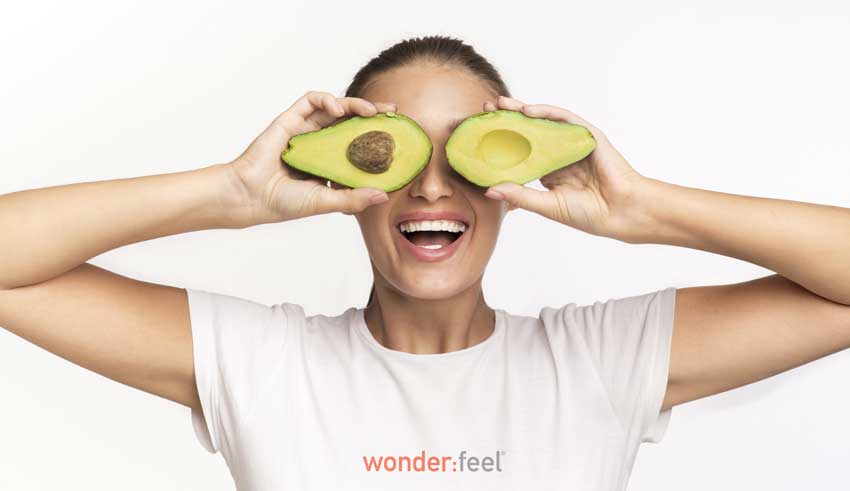 Two avocado halves over eyes representing the benefit of eating healthy fat with resveratrol